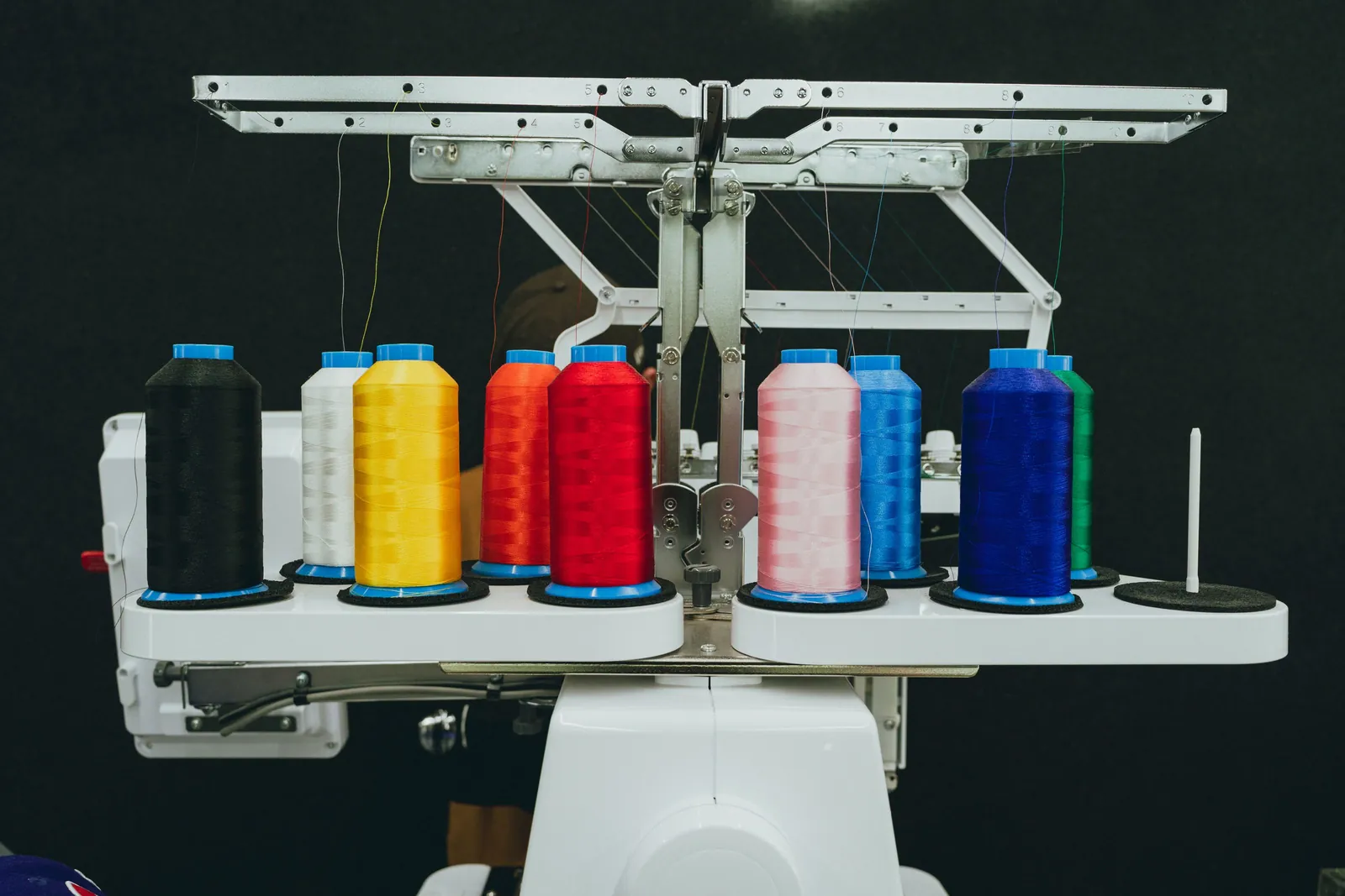 Colorful thread cones mounted on top of an industrial embroidery machine